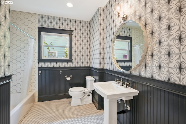 full bathroom with a wealth of natural light, tile patterned flooring, shower / tub combo with curtain, and toilet