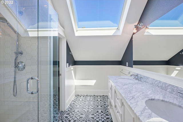 bathroom featuring a skylight, tile patterned flooring, vanity, and walk in shower