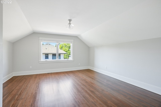 bonus room featuring dark wood-type flooring and vaulted ceiling