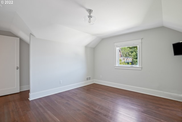 bonus room with dark hardwood / wood-style floors and vaulted ceiling