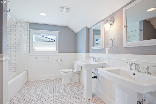 bathroom with shower / tub combo with curtain, dual sinks, lofted ceiling, and toilet