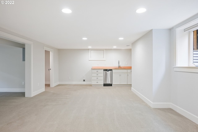 basement featuring light colored carpet and sink