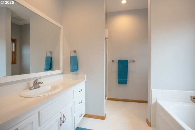 bathroom featuring vanity, a bath, recessed lighting, and baseboards