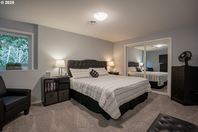 carpeted bedroom with a closet, visible vents, and a textured ceiling