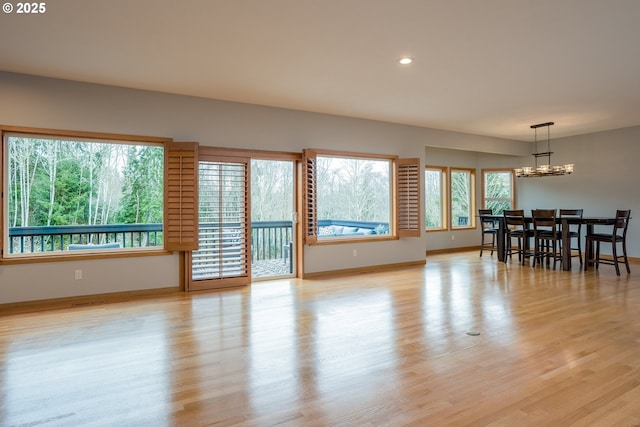 dining area featuring recessed lighting, light wood-style floors, baseboards, and a notable chandelier