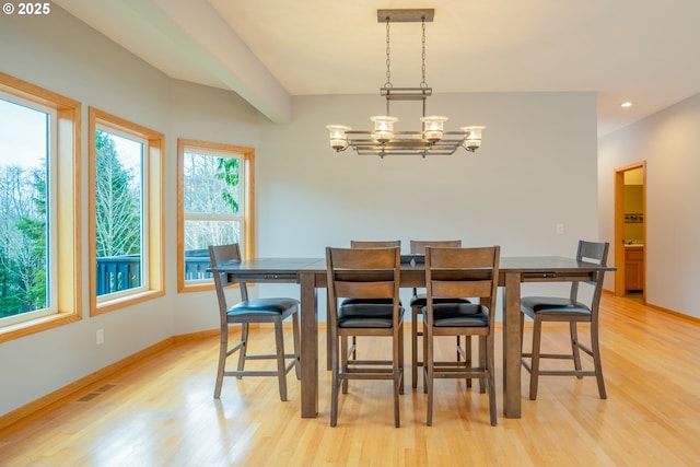 dining space featuring light wood-type flooring, baseboards, a notable chandelier, and visible vents