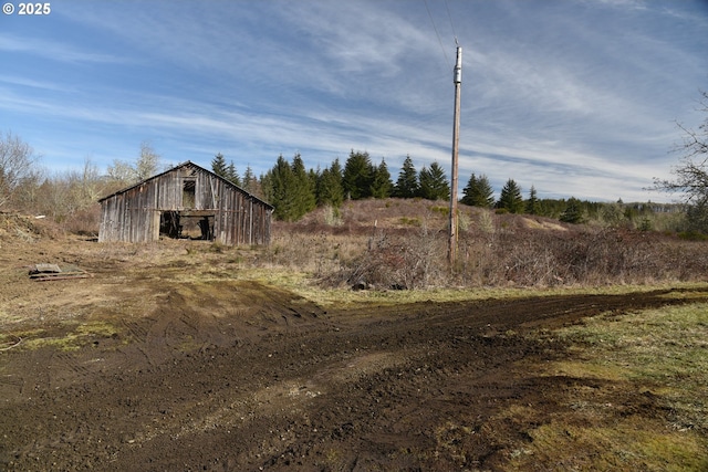 view of yard featuring an outdoor structure and a rural view