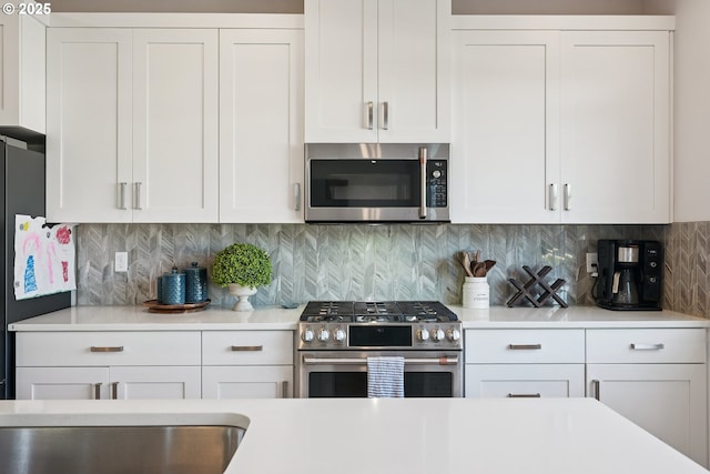 12545 SW Palermo St, Wilsonville, OR 97070 - kitchen with appliances with stainless steel finishes, light countertops, white cabinetry, and decorative backsplash