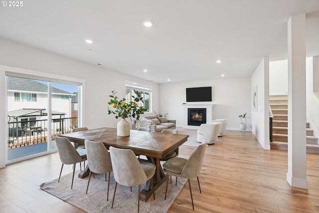 12545 SW Palermo St, Wilsonville, OR 97070 - dining area featuring light wood finished floors, stairs, recessed lighting, a glass covered fireplace, and baseboards