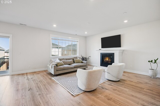 12545 SW Palermo St, Wilsonville, OR 97070 - living room featuring light wood finished floors, a glass covered fireplace, recessed lighting, and baseboards