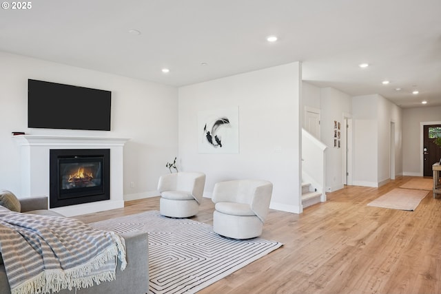 12545 SW Palermo St, Wilsonville, OR 97070 - living room with recessed lighting, light wood-style flooring, stairway, a glass covered fireplace, and baseboards