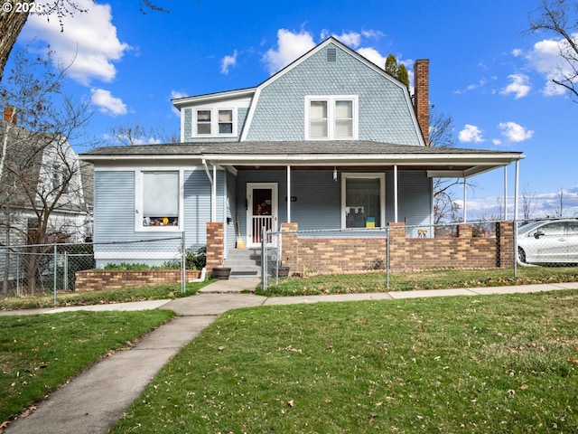 view of front of home featuring a porch, fence, a gambrel roof, and a front yard