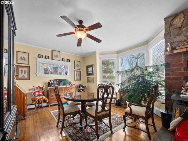 dining space featuring a ceiling fan, wood finished floors, a healthy amount of sunlight, and ornamental molding