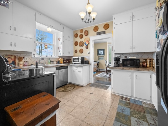 kitchen featuring light tile patterned floors, an inviting chandelier, black appliances, white cabinets, and tasteful backsplash