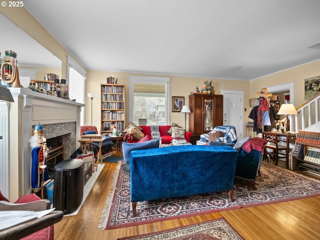 living room with a tile fireplace and wood finished floors