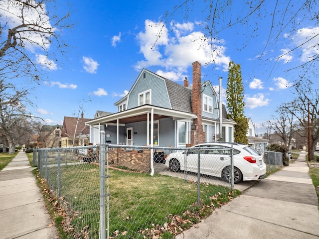 view of property exterior with a fenced front yard, a gambrel roof, a yard, and a chimney