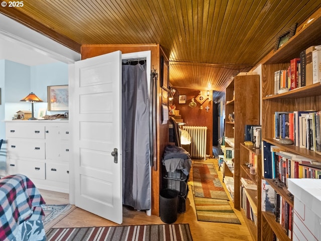 bedroom with wooden ceiling, radiator heating unit, and wood finished floors