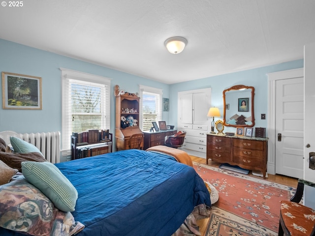 bedroom with light wood-style floors and radiator