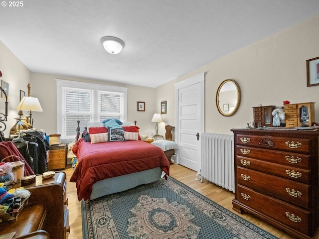 bedroom with radiator and light wood-type flooring