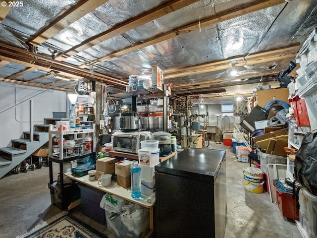 basement featuring stairs and fridge