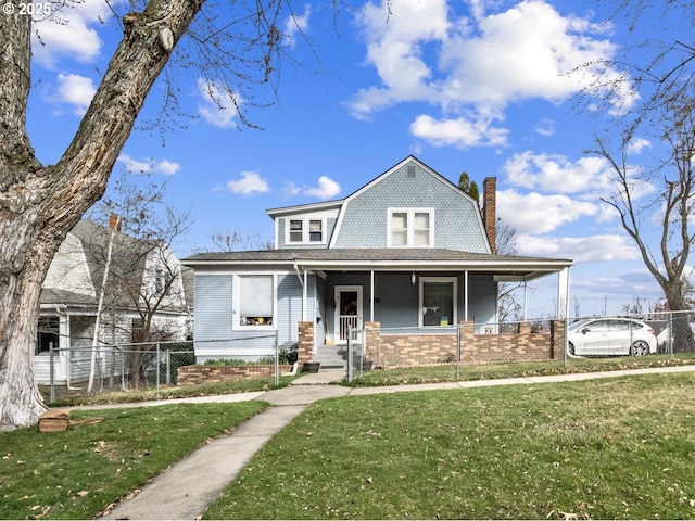 view of front of house featuring a gambrel roof, a porch, a front lawn, and fence