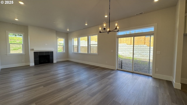 unfurnished living room featuring an inviting chandelier, visible vents, recessed lighting, and baseboards