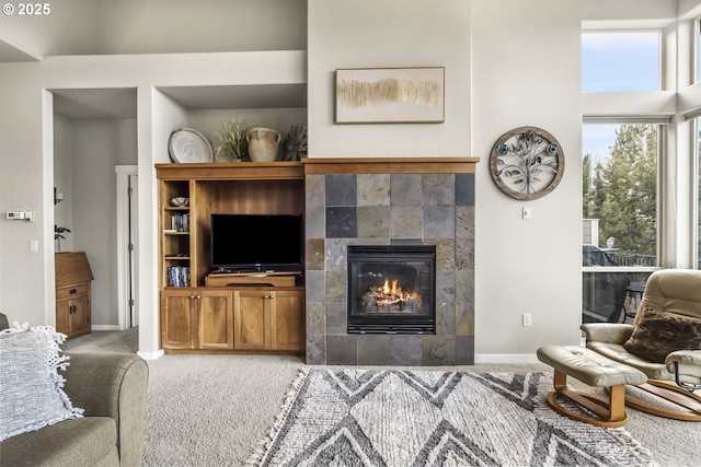 living room featuring a tiled fireplace and carpet