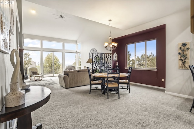 dining room with ceiling fan with notable chandelier, high vaulted ceiling, and carpet