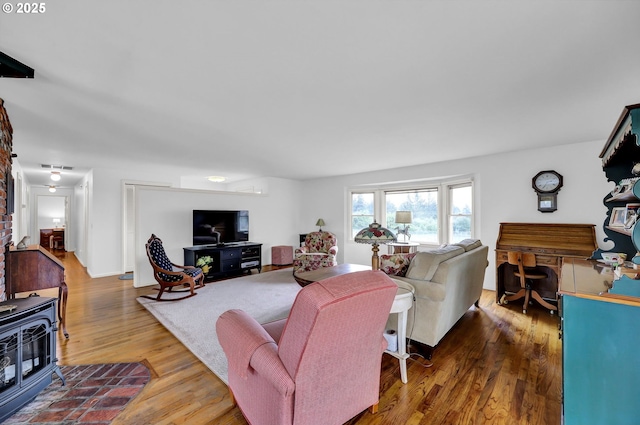 living room with a wood stove and wood finished floors
