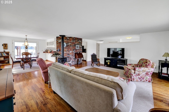 living area with wood finished floors and a wood stove