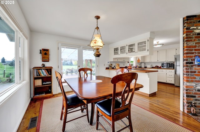 dining room with light wood-style floors and visible vents