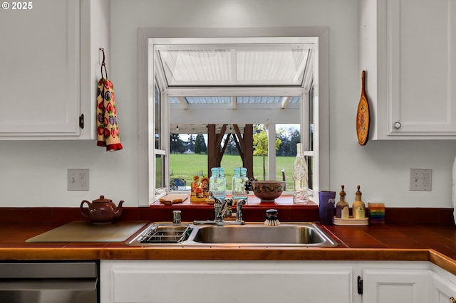 kitchen with a sink, white cabinetry, and dishwasher