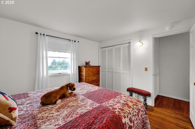 bedroom featuring a closet, baseboards, and wood finished floors