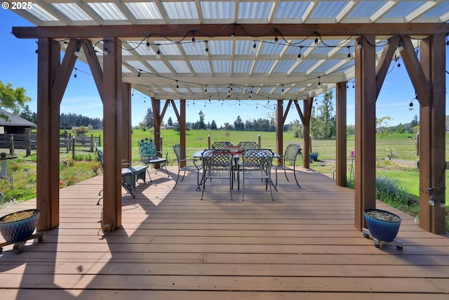 wooden terrace with a lawn, fence, and outdoor dining space