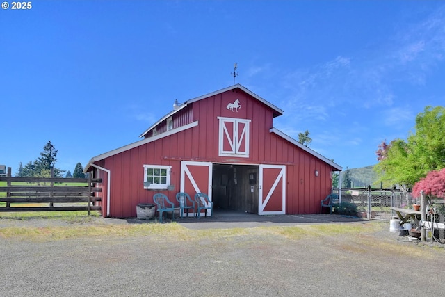 view of barn featuring fence
