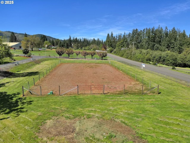 surrounding community featuring fence, a yard, and a rural view