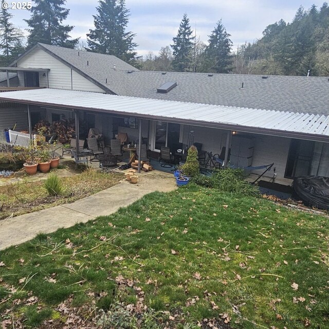 back of house with a lawn and a patio area