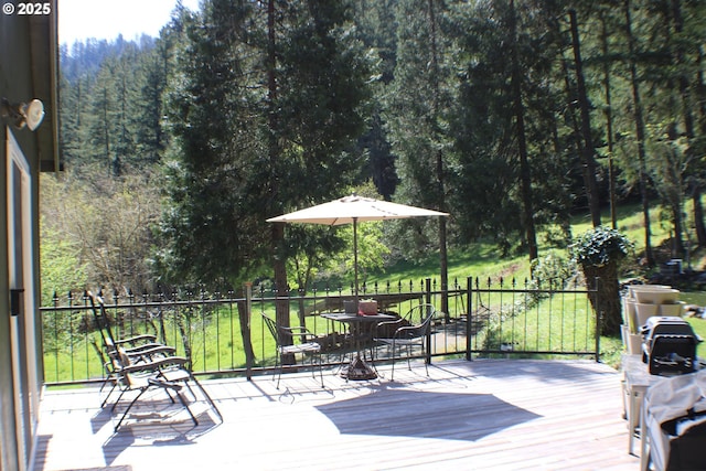 deck featuring a forest view and a yard
