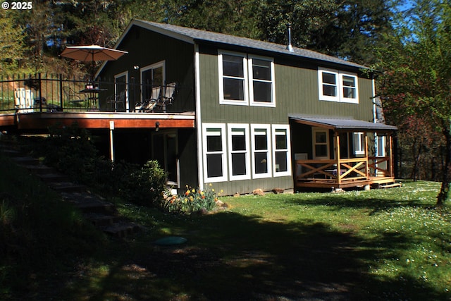 rear view of property featuring a wooden deck and a yard