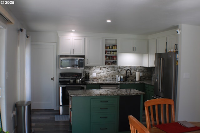kitchen featuring white cabinets, dark wood finished floors, stainless steel appliances, a sink, and decorative backsplash