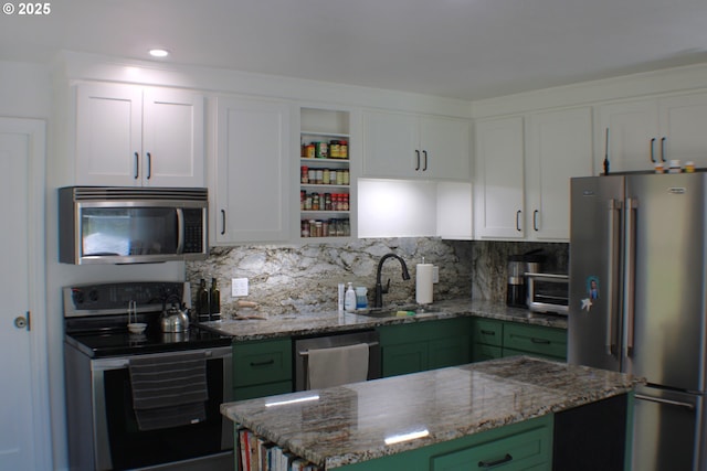 kitchen with white cabinets, appliances with stainless steel finishes, green cabinetry, and a sink