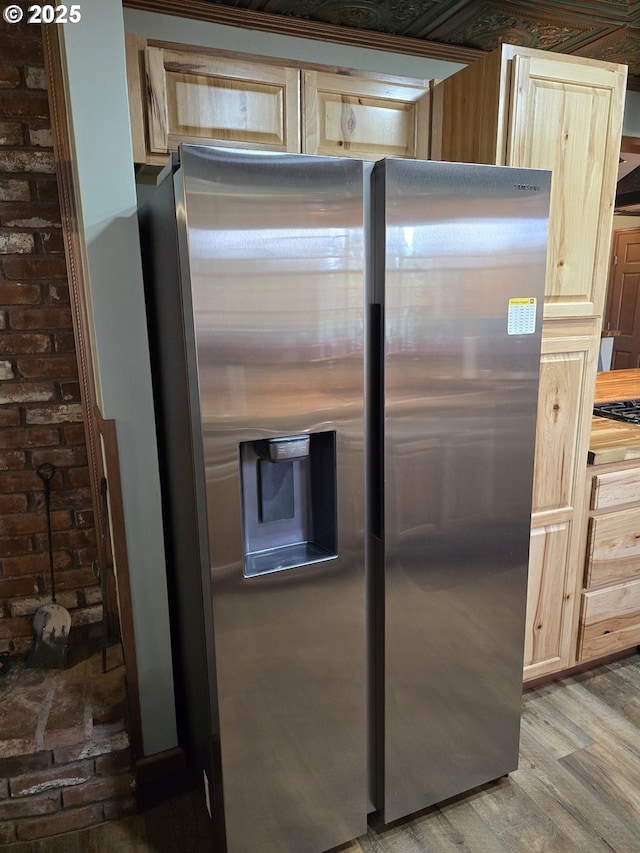 kitchen featuring stainless steel refrigerator with ice dispenser, light brown cabinets, hardwood / wood-style flooring, and gas stovetop