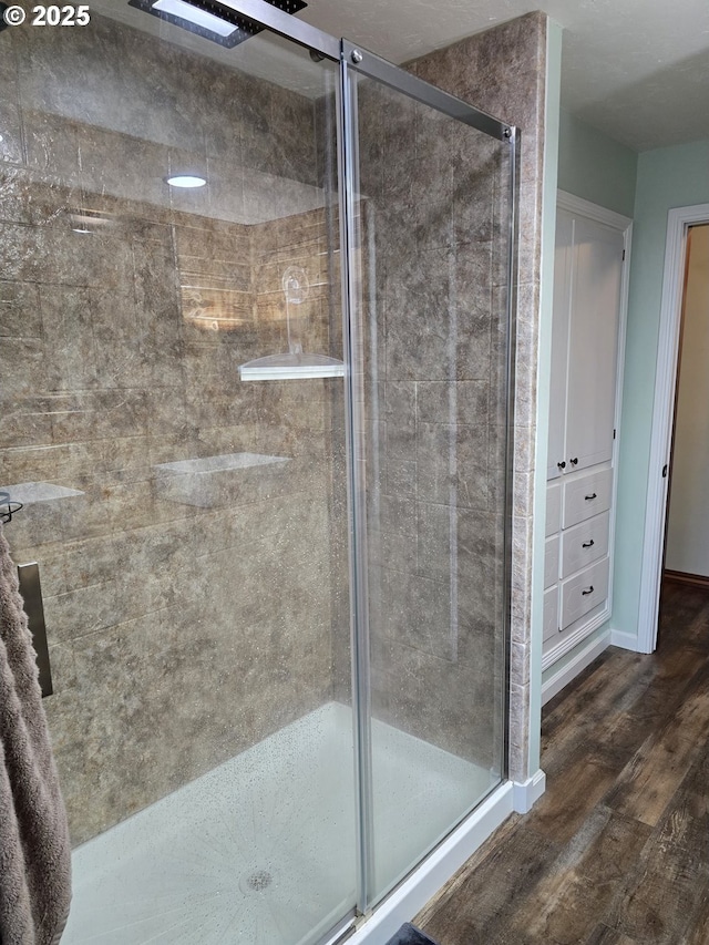 bathroom with hardwood / wood-style floors and an enclosed shower