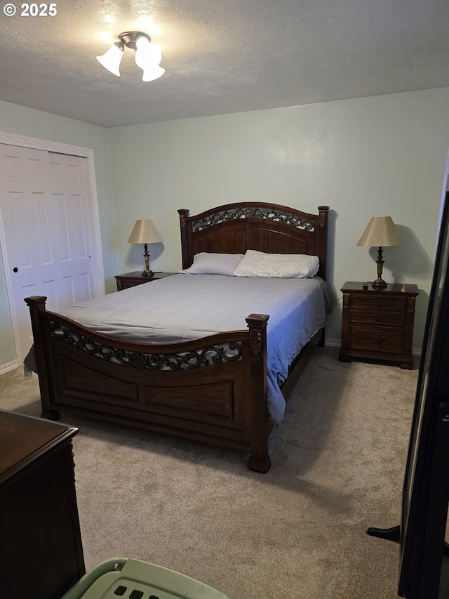 carpeted bedroom with a textured ceiling and a closet