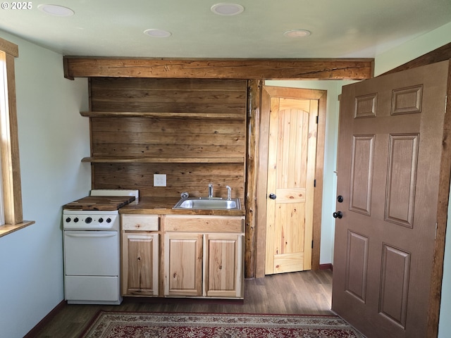 kitchen featuring beamed ceiling, stove, dark hardwood / wood-style floors, and sink