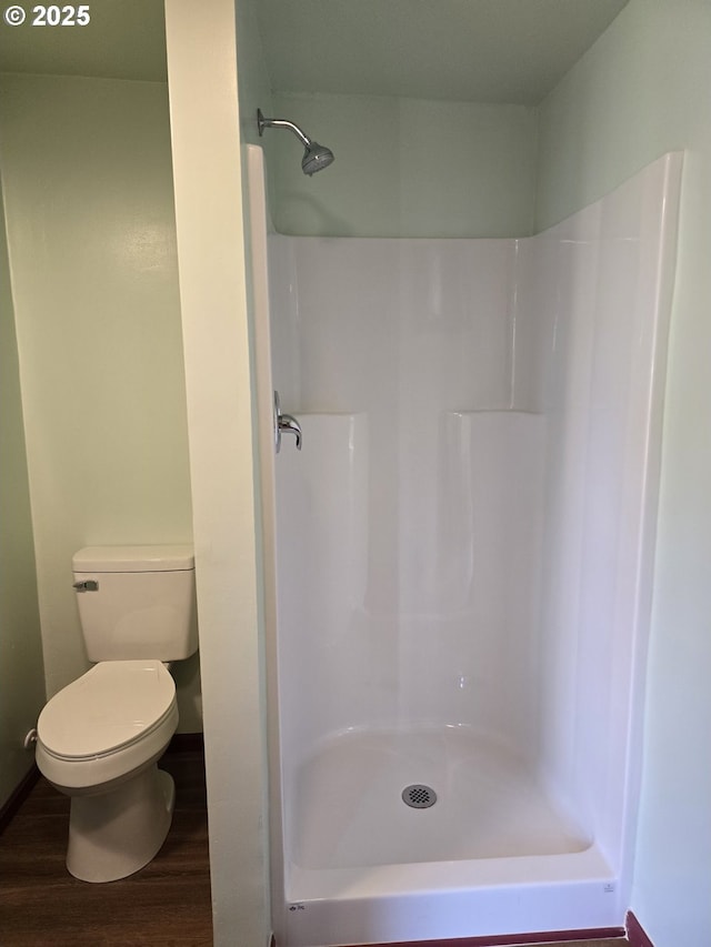 bathroom with a shower, wood-type flooring, and toilet