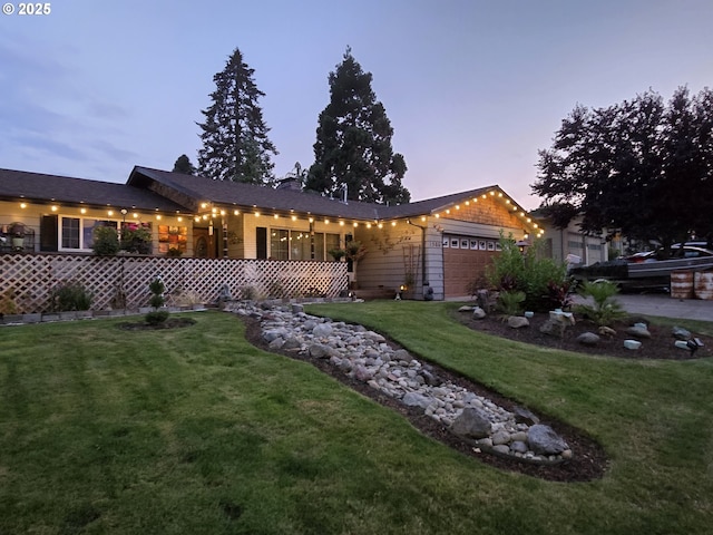 ranch-style home with a yard and a garage