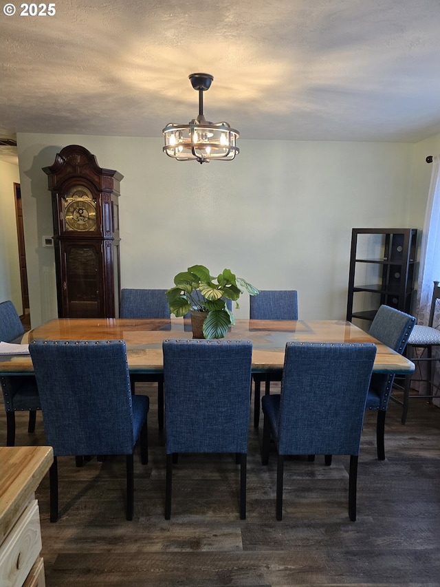 dining space featuring dark wood-type flooring and a notable chandelier