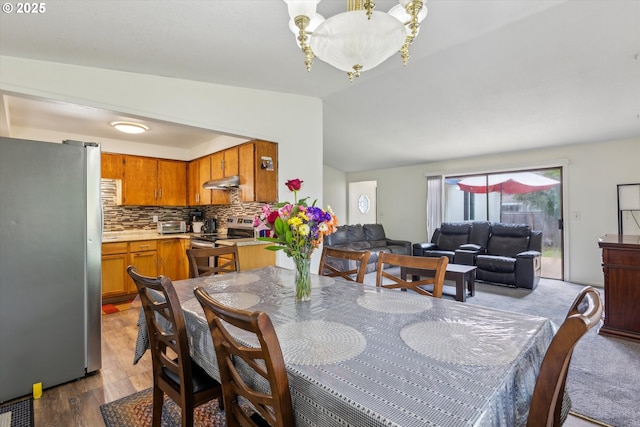 18366 SW Jann Dr, Beaverton, OR 97003 - dining area featuring lofted ceiling, wood finished floors, and a chandelier