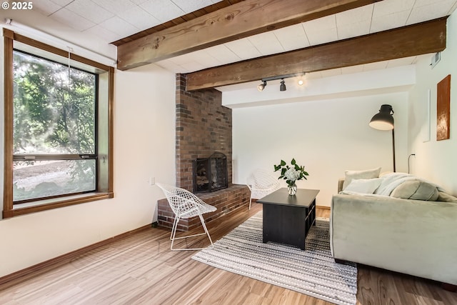 9080 NW Sherry Ct, Portland, OR 97229 - living room with wood finished floors, beam ceiling, a fireplace, and baseboards